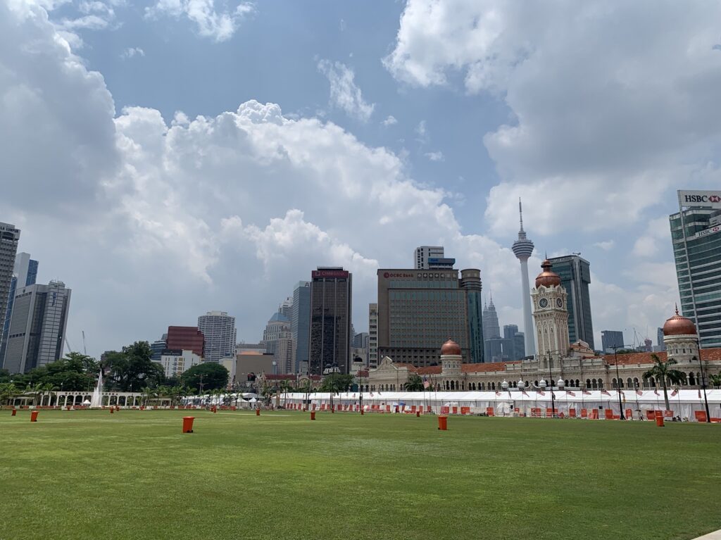 La Place de l'Indépendance (Merdeka Square) à Kuala Lumpur, avec la KL Tower et les tours Petronas en arrière-plan