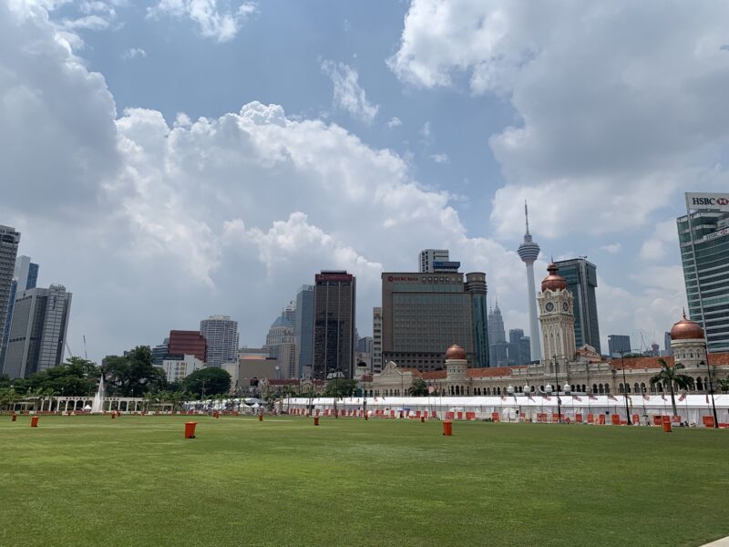 La Place de l'Indépendance (Merdeka Square) à Kuala Lumpur, avec la KL Tower et les tours Petronas en arrière-plan