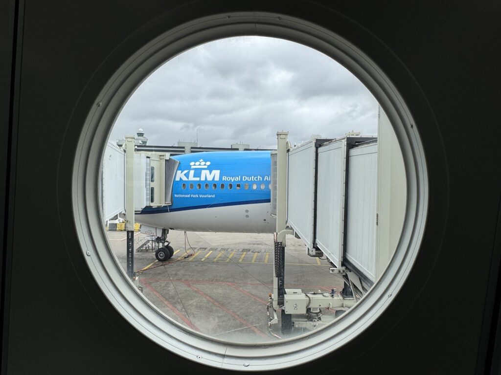 Un Boeing 777-300ER de KLM vu à travers le hublot d'une passerelle à l'aéroport d'Amsterdam-Schiphol