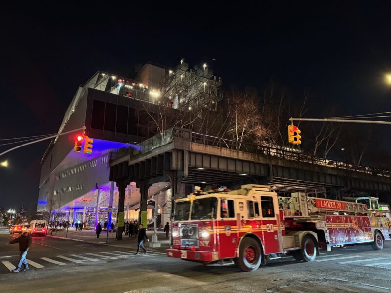 Un camion de pompiers passe devant le Whitney Museum de New York, de nuit
