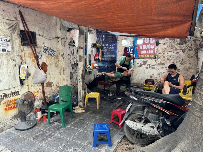Un salon de coiffure sur le trottoir d'une rue du district de Hai Ba Trung, à Hanoï (Vietnam)
