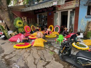 Des vendeuses confectionnent des couronnes de fleurs, une tradition ancrée dans la culture vietnamienne