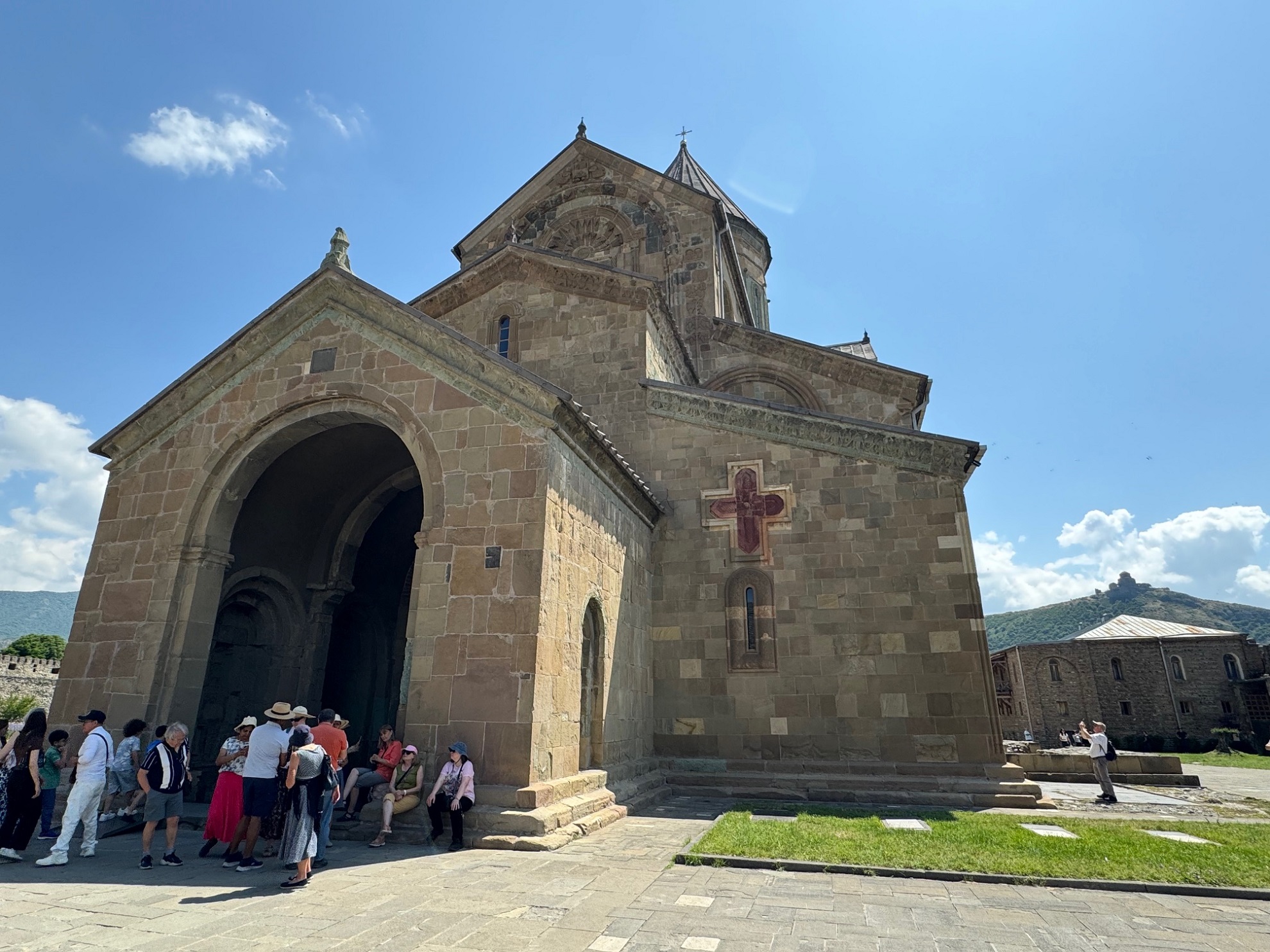 Vue sur l'entrée de la cathédrale de Svetitskhoveli à Mtskheta (Géorgie), avec au loin à droite le monastère de Jvari