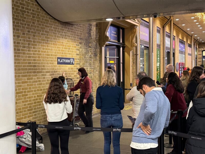 Des passants font la gare devant la plateforme 9 3/4 de Harry Potter, en Gare de King's Cross (juste en face de St Pancras)