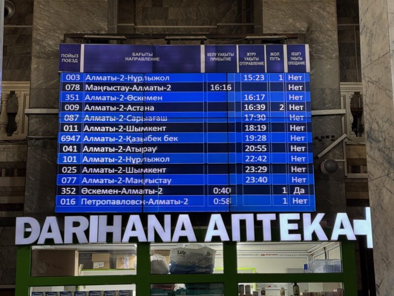 Vue sur le tableau des départs à la gare Almaty-2, uniquement écrit en écritures cyrilliques