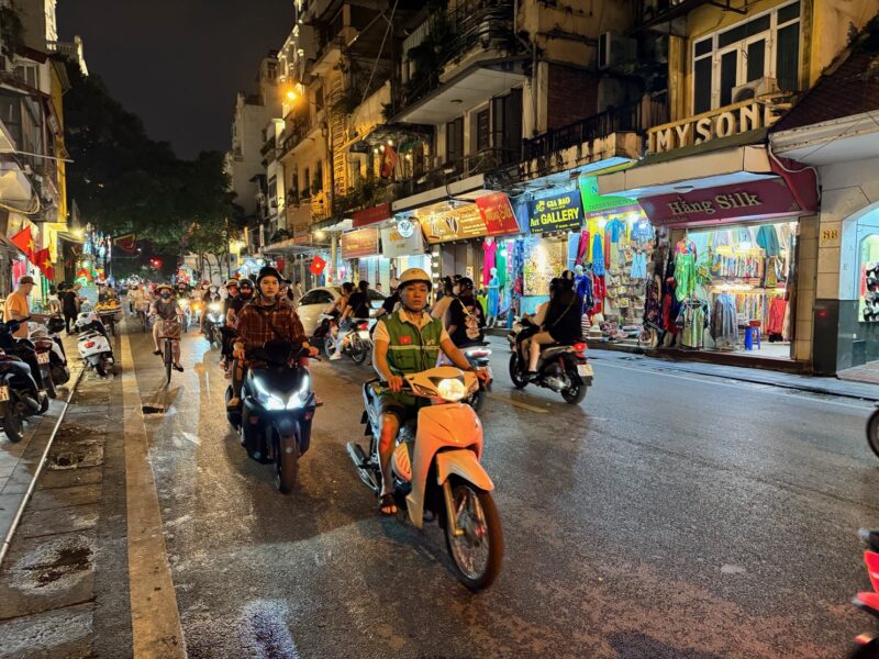 Des scooters dans une rue à Hanoï, en soirée (mais pas que...)