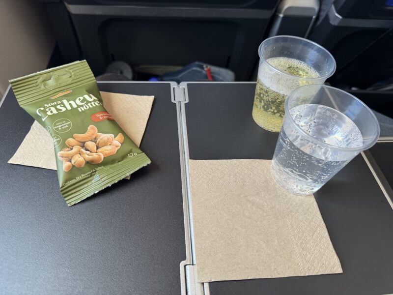 Le service de ce vol vers Tokyo débute par un apéritif : un sachet de noix de cajou, arrosé de champagne