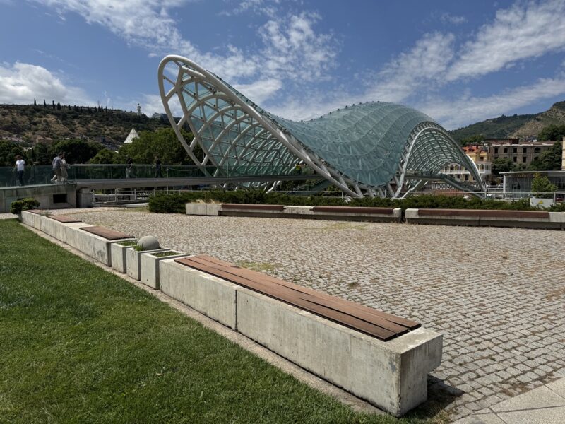 Le pont de la Paix contraste avec les bâtiments historiques qui l'entourent dans le Vieux Tbilissi