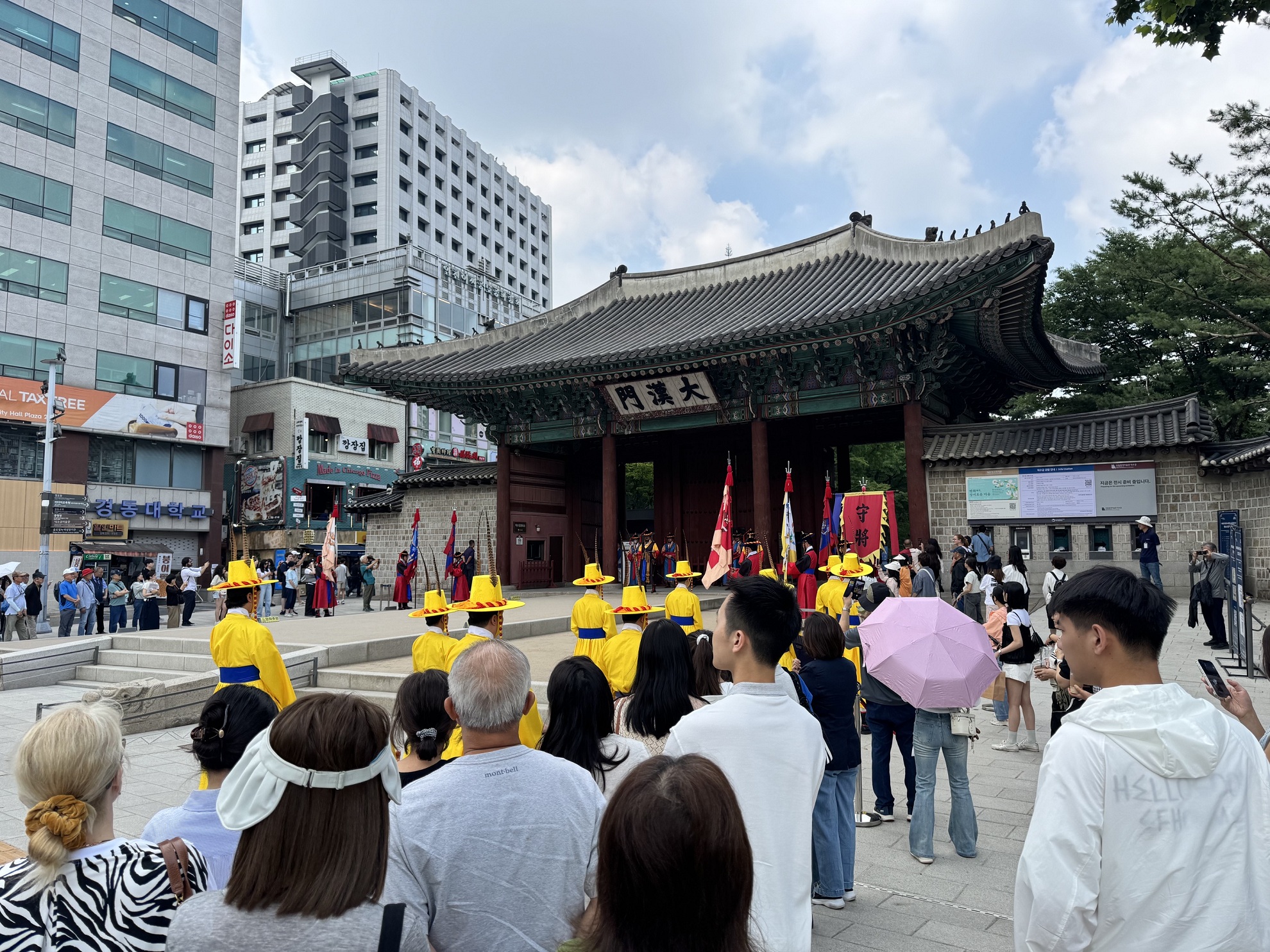 Le public assiste à la relève de la garde, devant l'entrée principale du palais Deoksugung à Séoul (Corée du Sud)
